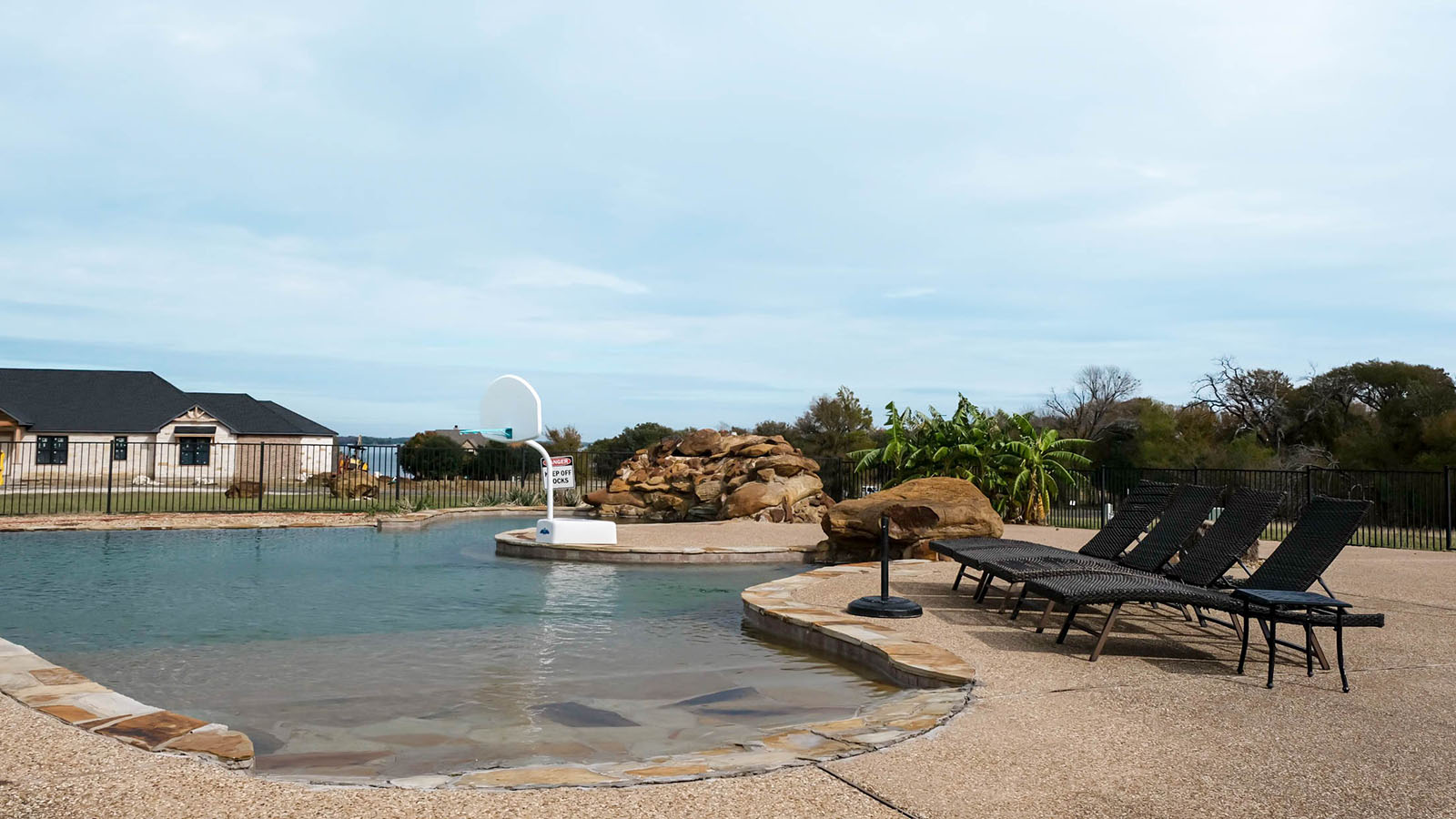 A view of the community pool with lake views in the background.